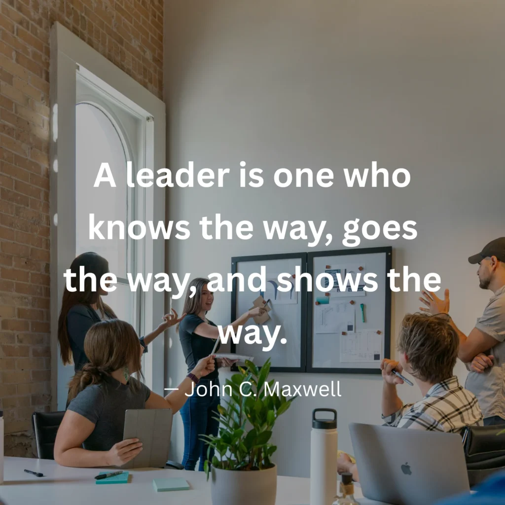 An inspirational graphic featuring a team collaborating in an office setting with text: "A leader is one who knows the way, goes the way, and shows the way." – John C. Maxwell