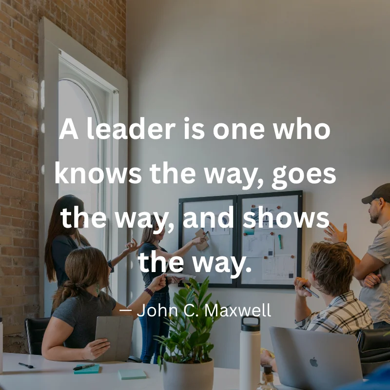 An inspirational graphic featuring a team collaborating in an office setting with text: "A leader is one who knows the way, goes the way, and shows the way." – John C. Maxwell